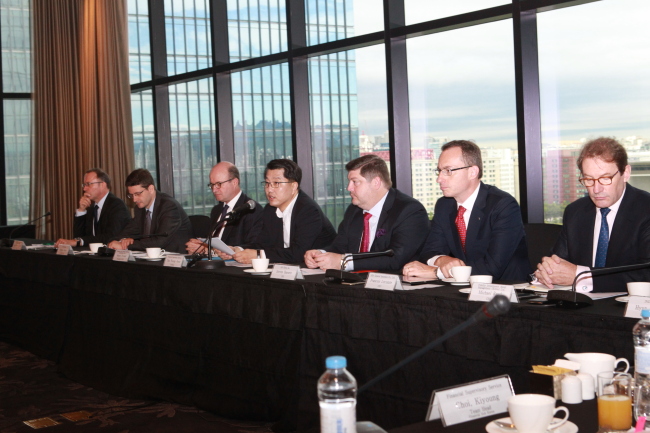 Zhin Woong-seob (fourth from right), governor of the Financial Supervisory Service, speaks Thursday in a regular breakfast meeting with 22 foreign financial firms operating in Korea. At the meeting, the governor urged the CEOs to take more proactive measures to reduce customer complaints and also promised to achieve an improved supervisory environment for domestic and foreign firms.   FSS