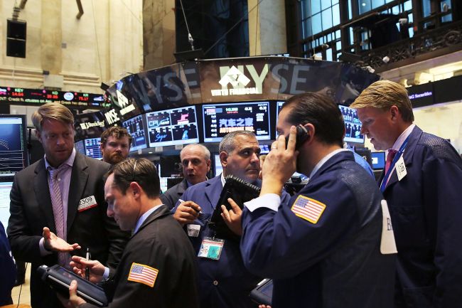 Traders work on the floor of the New York Stock Exchange at the close of the day after trading was paused for nearly four hours due to a "technical glitch" in New York City, Wednesday. (AFP)