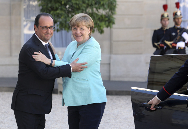 France's President Francois Hollande (left) welcomes German Chancellor Angela Merkel prior to a meeting in Paris on July 6.
(AP-Yonhap)