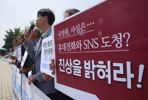Activists hold a rally in front of the National Assembly, Tuesday, urging the NIS to "reveal the truth." (Yonhap)
