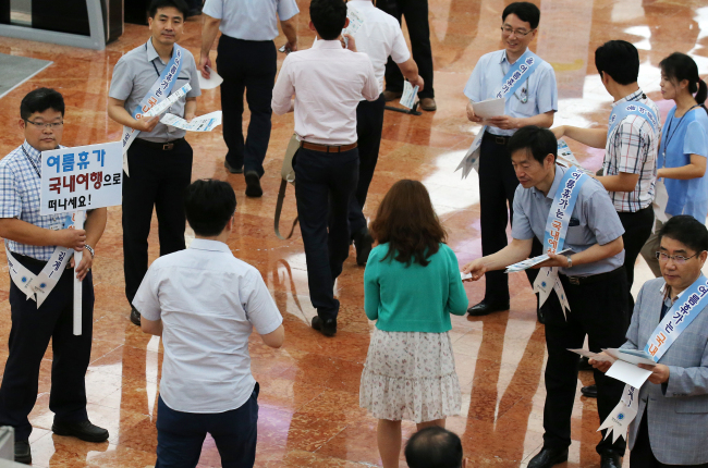 <YONHAP PHOTO-0480> 중앙부처 공무원 국내휴가 독려, 행자부 캠페인 (서울=연합뉴스) 전수영 기자 = 행정자치부 소속 공무원들이 20일 오전 정부서울청사에서 중앙부처 공무원들에게 '여름 휴가철 유용한 공공정보 10선' 같은 홍보물을 나눠주며 국내휴가를 독려하고 있다. 행자부는 중동호흡기증후군(메르스)의 직격탄을 맞은 지역경제 회복을 돕기 위해 자치단체·지방공기업과 함께 이달 24일까지 '여름휴가 국내여행 가기' 캠페인을 정부서울청사를 시작으로 전국 10개 모든 정부청사에서 실시한다. 2015.7.20 swimer@yna.co.kr/2015-07-20 09:00:07/ <저작권자 ⓒ 1980-2015 ㈜연합뉴스. 무단 전재 재배포 금지.>