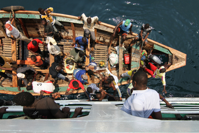 A child is handed between a small boat and the MV Liemba, which takes passengers across Lake Tanganyika between Tanzania and Zambia.(Albert Reteief)