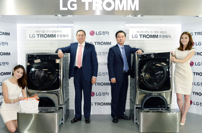 Cho Seong-jin (second from left), CEO of LG’s home appliance and air solution company, and Choi Sang-gyu (second from right), head of LG’s Korea sales and marketing, pose with models at a launch event of the Tromm Twin Wash, featuring two washing drums.   LGE