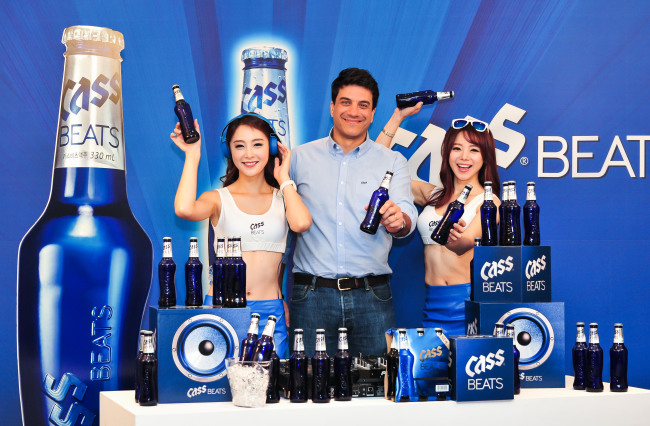 Oriental Brewery CEO Kim Do-hun (center) and models promote Cass Beats at a launch in Seoul on Thursday.   OB