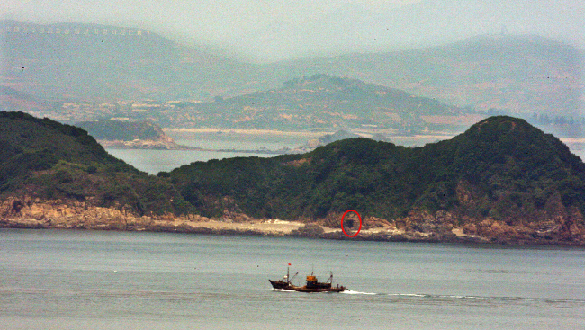 This file photo shows North Korea’s forward-deployed artillery piece, marked with a red circle, at its border island of Galdo, 4.5 km from South Korea’s Yeonpyeongdo Island. (Yonhap)
　