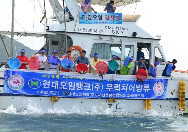 　SHARED GROWTH -- Seosan City mayor Lee Wan-seop (fourth from left) and Hyundai Oilbank staffers release a total of 150,000 baby rockfish into the sea near Samgilpo Port in South Chungcheong Province in the refiner’s effort to support the local fisheries industry. (Hyundai Oilbank)