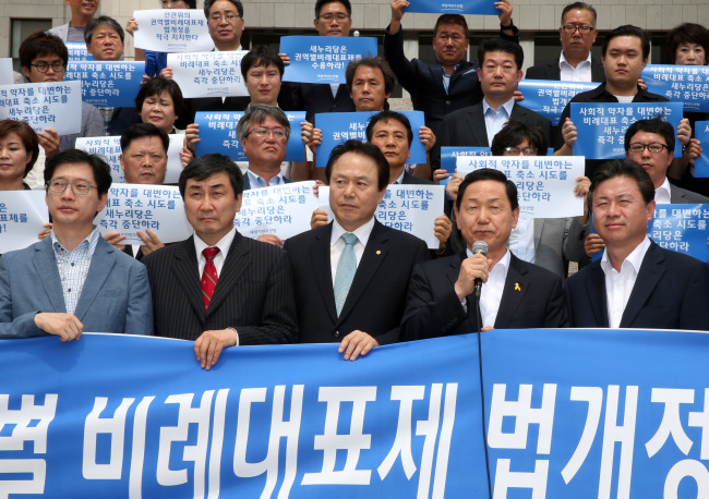 NPAD members hold a rally calling for a new proportional representation system in front of the main National Assembly hall on Tuesday. (Yonhap)
　