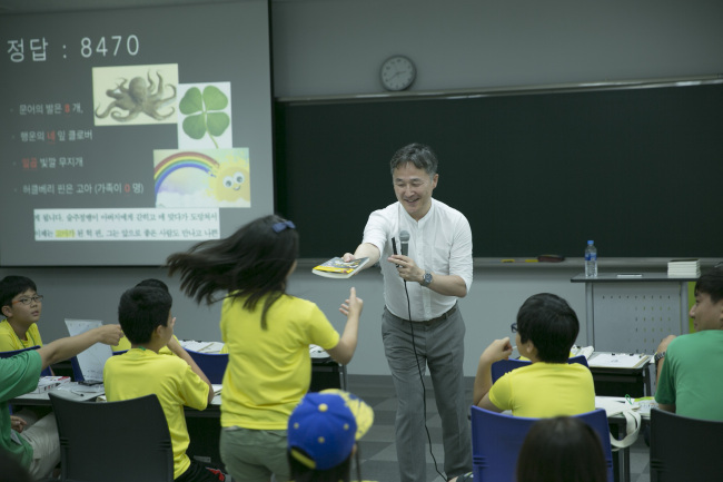 LS니꼬동제련이 지난달 말 울산과기대에서 개최한 에코 사이언스 캠프의 한 프로그램인 범죄 추리 체험 시간에서 표창원범죄과학연구소 대표 표창원 박사가 퀴즈를 맞춘 어린이에게 책을 선물하고 있다.［사진제공=LS니꼬동 제련］