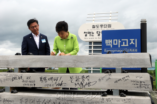 박근혜 대통령이 5일 오전 강원도 철원 백마고지역에서 경원선 남측 구간 복원 공사 기공식에 참석에 앞서 침목에 통일 메시지를 쓰고 있다. 왼쪽은 홍용표 통일부 장관. (한반도) 평화통일과 새로운 미래개척. 2015. 8.5 대통령 박근혜)/ 안훈 기자 rosedale@heraldcorp.com 2015.08.05