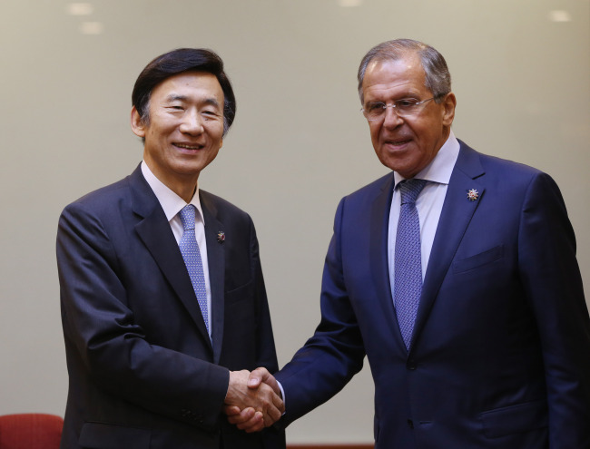 South Korean Foreign Minister Yun Byung-se (left) shakes hands with his Russian counterpart Sergey Lavrov before their talks on the sidelines of the ASEAN Regional Forum in Malaysia on Wednesday. (Yonhap)
