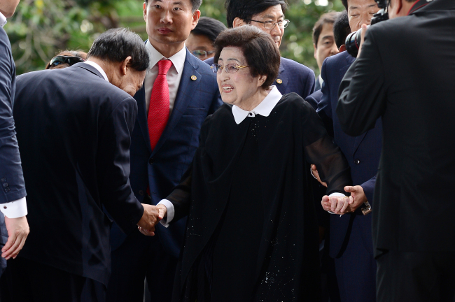Former first lady Lee Hee-ho (center) is greeted by officials as she arrives at Gimpo International Airport to head to North Korea on Wednesday. (Yonhap)