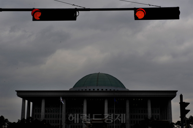▶먹구름이 드리워진 국회의사당에 빨간신호들이 켜져있다.(이 사진은 기사의 특정내용과 관련이 없음)