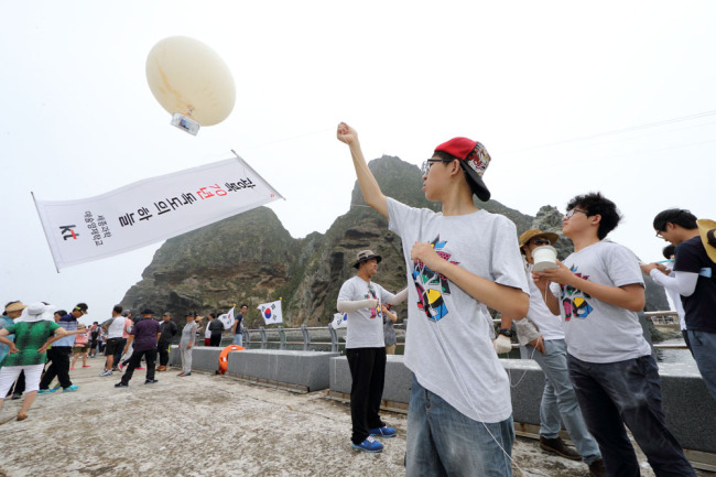 COMMEMORATION OF LIBERATION -- Students from the Sejong Academy of Science and Arts release helium balloons fitted with cameras to take aerial photos of the easternmost islets of Dokdo in an event held by mobile carrier KT on Thursday. The event was organized to mark the 70th anniversary of Korea’s independence from Japan’s colonial rule, which falls on Aug. 15. (KT)
　
