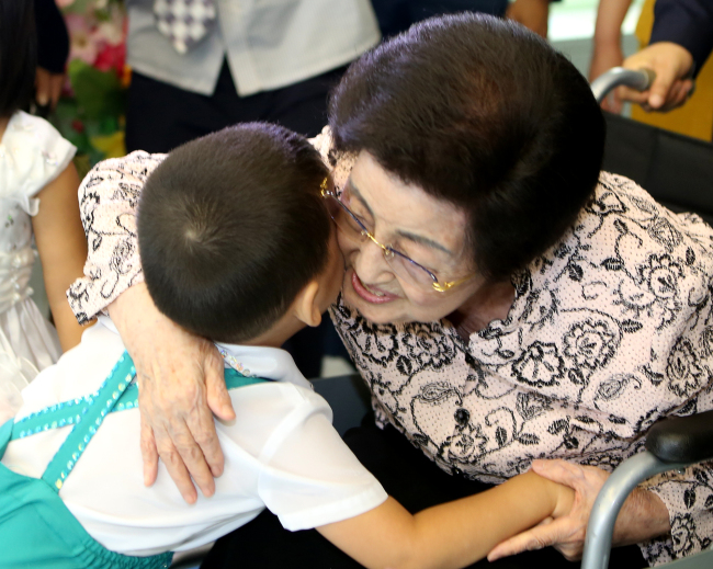Lee Hee-ho hugs a child during her visit to Aeyukone, an orphanage for kindergarteners in Pyongyang last Thursday.   Kim Dae-jung Peace Center