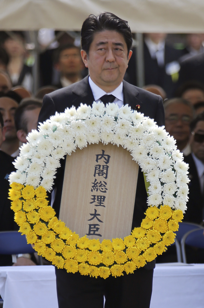 Japanese Prime Minister Shinzo Abe holds a wreath during a ceremony to mark the 70th anniversary of the Nagasaki atomic bombing in Nagasaki, Japan, Sunday. AP-Yonhap