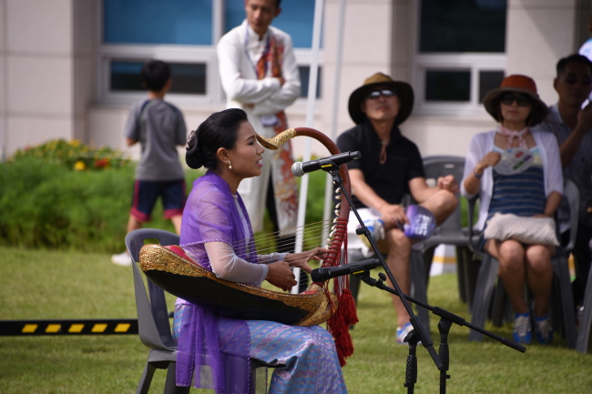 An artist from Myanmar plays the traditional Burmese harp at the DMZ Peace Art Festival in Ganghwado Island on Sunday. (The Korea National University of Arts)