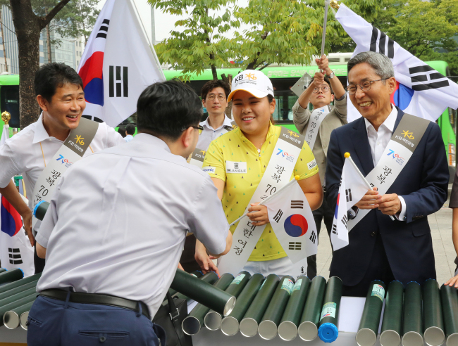 윤종규 KB금융회장 겸 국민은행장과 박인비 선수가 고객들에게 태극기를 나눠주는 모습
사진=KB국민은행 제공