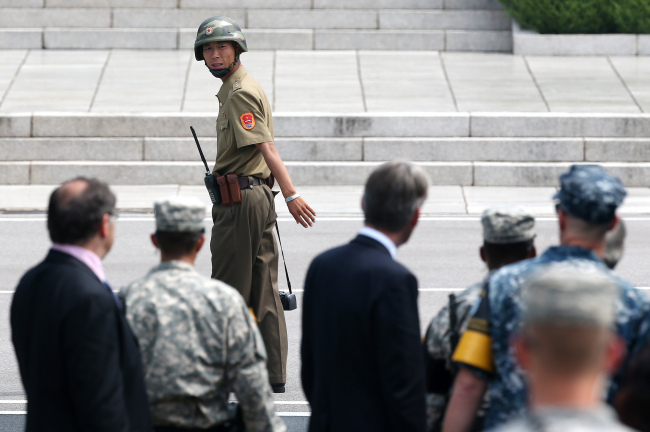 <YONHAP PHOTO-1412> 뒤돌아보는 북한군 병사 (판문점=연합뉴스) 임헌정 기자 = 필립 해먼드 영국 외교장관이 11일 판문점을 방문했다. 북한군 병사가 해먼드 장관 일행을 카메라로 촬영한 뒤 뒤를 돌아보고 있다. 2015.8.11 kane@yna.co.kr/2015-08-11 12:44:51/ <저작권자 ⓒ 1980-2015 ㈜연합뉴스. 무단 전재 재배포 금지.>
A North Korean soldier glances at a delegation led by British Foreign Secretary Philip Hammond at the border village of Panmunjeom on Tuesday.    Yonhap
A North Korean soldier glances at a delegation led by British Foreign Secretary Philip Hammond at the border village of Panmunjeom on Tuesday.    Yonhap