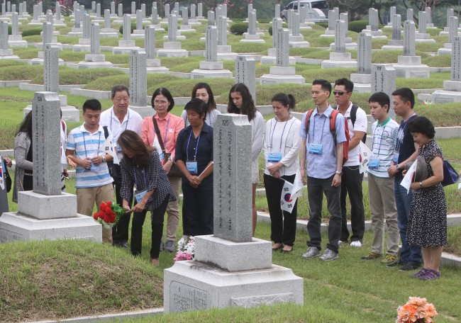 <YONHAP PHOTO-1689> 헌화하는 외국 거주 독립유공자 후손들 (대전=연합뉴스) 이재림 기자 = 광복 70주년을 나흘 앞둔 11일 대전 유성구 국립대전현충원 애국지사 안원규 선생 묘소에서 안 선생의 손녀 맥신 난화 셰아 씨를 비롯한 외국 거주 독립유공자 후손들이 헌화하며 참배하고 있다. 2015.8.11 walden@yna.co.kr/2015-08-11 14:30:08/ <저작권자 ⓒ 1980-2015 ㈜연합뉴스. 무단 전재 재배포 금지.>
The granddaughter of late patriot Ahn Won-kyu offers flowers to honor him at his grave in Daejeon National Cemetery, Tuesday, along with other descendants of independence fighters living overseas.   Yonhap
The granddaughter of late patriot Ahn Won-kyu offers flowers to honor him at his grave in Daejeon National Cemetery, Tuesday, along with other descendants of independence fighters living overseas.   Yonhap