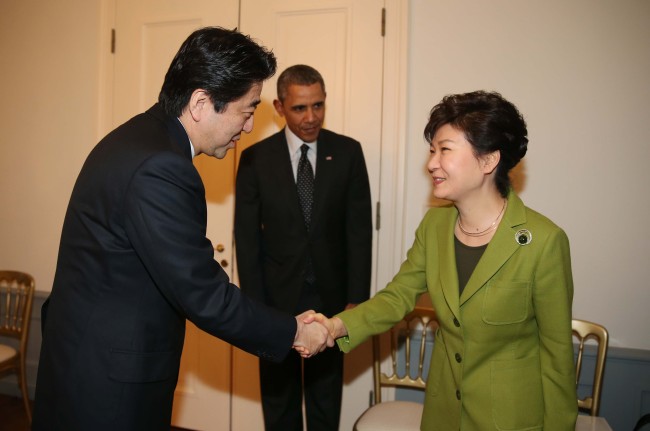 South Korean President Park Geun-hye shakes hands with Japanese Prime Minister Shinzo Abe with U.S. President Barack Obama observing at a trilateral meeting held on the sidelines of the Nuclear Security Summit in The Hague, Netherlands, in March 2014. (Park Hae-mook/ The Korea Herald)