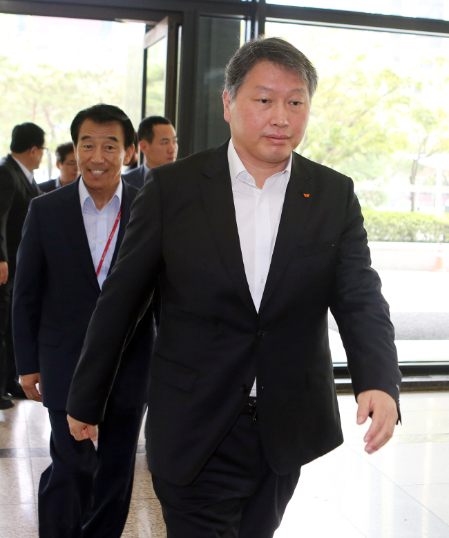 The recently-pardoned SK Group chairman Chey Tae-won (right) enters the SK Group headquarters with company officials, including SK SUPEX Council chairman Kim Chang-geun, on Saturday to discuss pending issues in management. (SK Group)