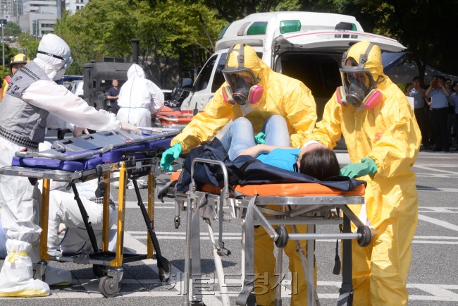 서울시 서초구청은 18일 오전 최근 중동호흡기증후군(MERS)로 인하여 피해를 입은 교훈을 바탕으로 <br />생물무기 사고시 대응 조치가 절실하다는 판단에 따라 2015년 을지연습기간에<br />전시 감염병(페스트,탄저균) 테러 대비 훈련을 민.관.군.경.소방 통합으로 서초구청 광장에서 실시하고 있다.<br />박현구 기자phko@heraldcorp.com/ 2015.08.18
서울시 서초구청은 18일 오전 최근 중동호흡기증후군(MERS)로 인하여 피해를 입은 교훈을 바탕으로
생물무기 사고시 대응 조치가 절실하다는 판단에 따라 2015년 을지연습기간에
전시 감염병(페스트,탄저균) 테러 대비 훈련을 민.관.군.경.소방 통합으로 서초구청 광장에서 실시하고 있다.
박현구 기자phko@heraldcorp.com/ 2015.08.18
민ㆍ관ㆍ군ㆍ경ㆍ소방관계자들이 18일 오전  서울시 서초구청 광장에서 생물무기 사고 대응훈련을 하고 있다. 서초구는  최근 중동호흡기증후군(MERS)로 인하여 피해를 입은 교훈을 바탕으로 생물무기 사고시 대응 조치가 절실하다는 판단에 따라 2015년 을지연습기간에 전시 감염병(페스트, 탄저균) 테러 대비 훈련을 민ㆍ관ㆍ군ㆍ경ㆍ소방 통합으로 서초구청 광장에서 실시했다. 박현구 기자/phko@heraldcorp.com
