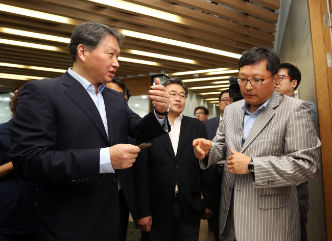 SK Group chairman Chey Tae-won (left) talks with the head of a venture firm at the Daejeon Creative Economy Center on Tuesday. (SK Group)