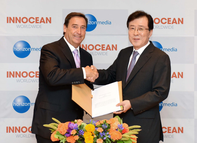 Innocean Worldwide CEO Ahn Kun-hee (right) shakes hands with Bill Koenigsberg, CEO and president of U.S.-based Horizon Media, after sealing a deal to set up a joint venture, in Seoul last week. (Innocean WorldWide)　