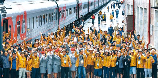 Participants of the Seoul-led Eurasia Express journey wave for a photo at Perm Station in Russia on July 25 during their 14,400-kilometer trip from Beijing and Vladivostok to Berlin. (Yonhap)