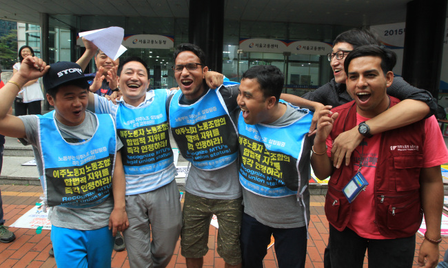 Members of the Seoul-Gyeonggi-Incheon Migrants’ Trade Union celebrate after the union was recognized in central Seoul, Thursday.   Yonhap