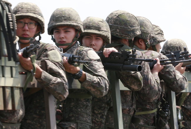 <YONHAP PHOTO-0847> 긴장감 (파주=연합뉴스) 이상학 기자 = 남북이 북한의 서부전선 포격도발에 따른 한반도 긴장 고조 상황을 해소하기 위한 고위급 접촉이 예정된 23일 무장한 장병들이 차량에 탑승하고 파주시 통일대교를 건너고 있다. 2015.8.23 leesh@yna.co.kr/2015-08-23 12:52:05/ <저작권자 ⓒ 1980-2015 ㈜연합뉴스. 무단 전재 재배포 금지.>
Armed South Korean soldiers ride a military vehicle across the Tongil Bridge in Paju, Gyeonggi Province, near the border village of Panmunjeom, where high-level inter-Korean talks were taking place Sunday.    Yonhap