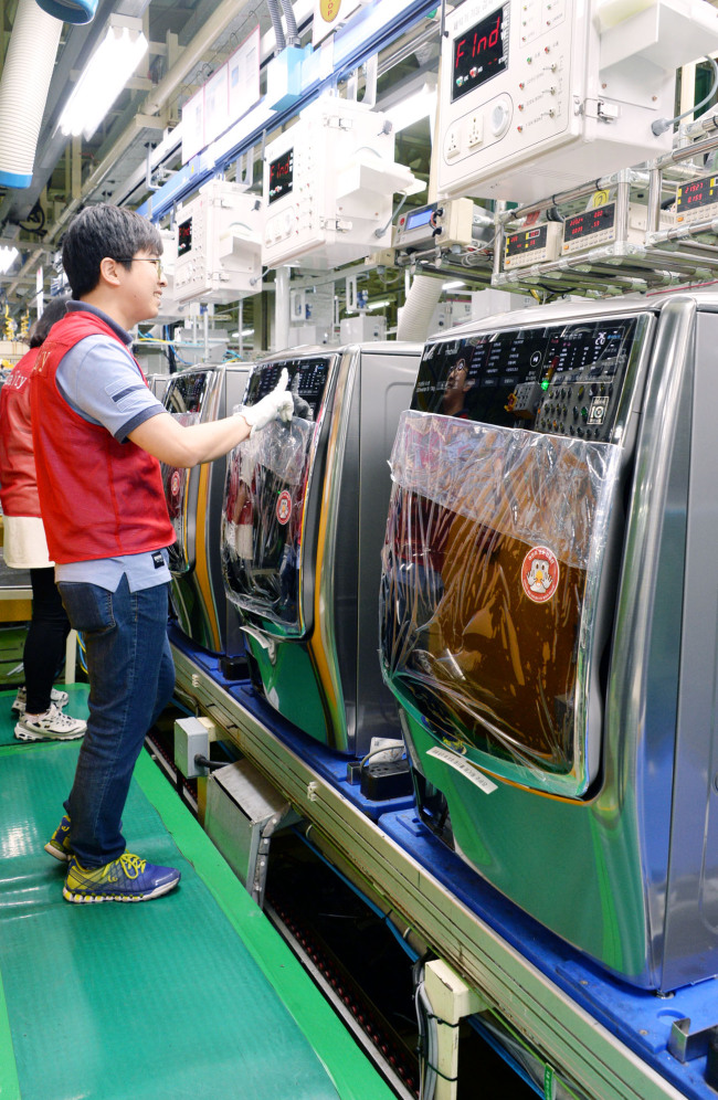 LG Electronics employees work at the assembly line in Changwon, South Gyeongsang Province, on Friday. (LGE)