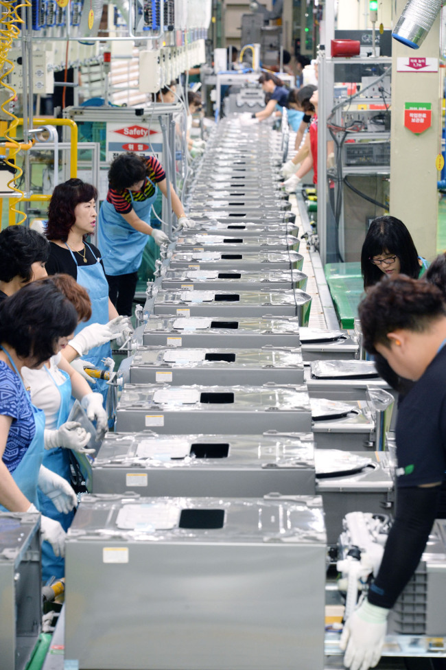 LG Electronics employees work at the assembly line in Changwon, South Gyeongsang Province, on Friday. (LGE)
