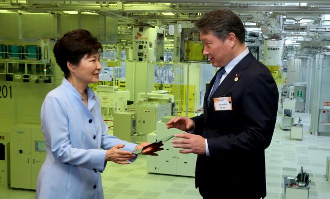 President Park Geun-hye (left) and SK Group chairman Chey Tae-won talk at SK hynix's new chip plant in Icheon, Gyeonggi Province, Tuesday. Yonhap