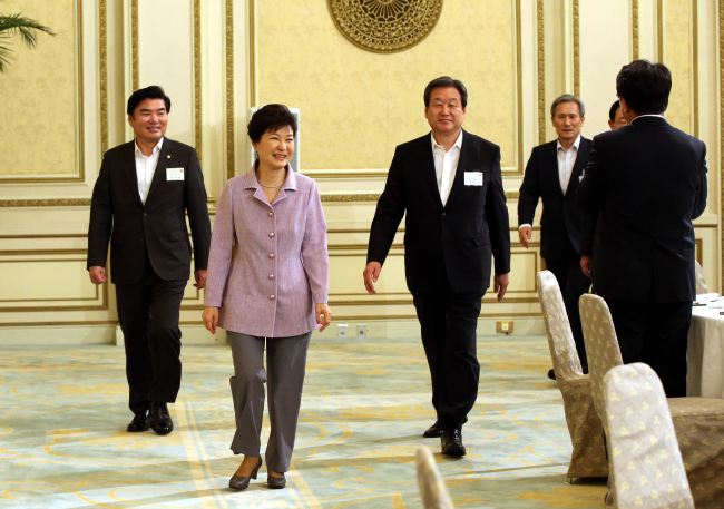 President Park Geun-hye walks in to a luncheon for Saenuri Party lawmakers with National Security Office chief Kim Kwan-jin (right), party chairman Rep. Kim Moo-sung (second from right) and floor leader Rep. Won Yoo-chul at Cheong Wa Dae on Wednesday. (Yonhap) 　