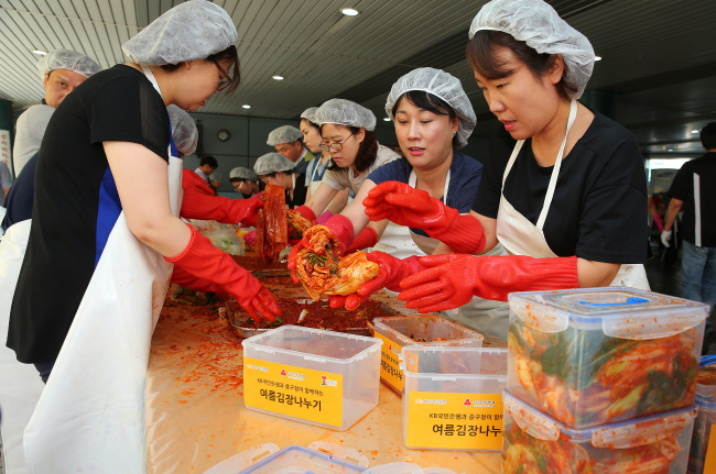<YONHAP PHOTO-1658> 여름김장 아시나요? (서울=연합뉴스) 황광모 기자 = 30일 오전 서울 중구 신당종합사회복지관에서 열린 사랑의 여름김장나누기 행사에 참가한 KB국민은행들이 독거노인 등 저소득충에 전달될 김치를 담그고 있다. 이날 담근 여름김장은 중구 관내 580여세대에 전달됐다. 2015.8.30 hkmpooh@yna.co.kr/2015-08-30 14:04:11/ <저작권자 ⓒ 1980-2015 ㈜연합뉴스. 무단 전재 재배포 금지.>