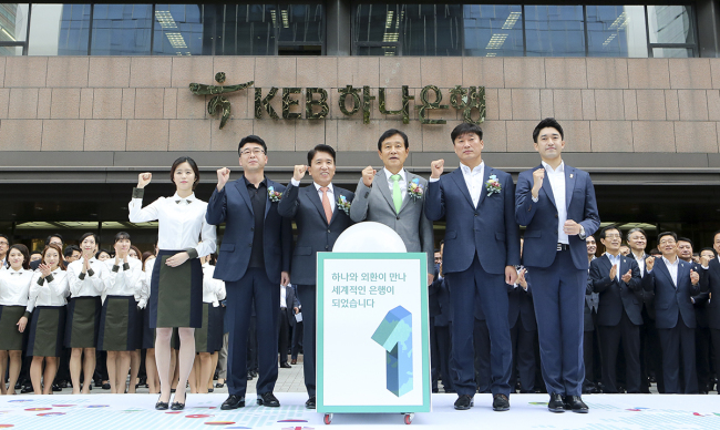 Hana Financial Group chairman Kim Jung-tai (center, front row) and KEB Hana Bank president Ham Young-joo (fourth from right, front row) attend the launching ceremony of KEB Hana Bank in the bank’s headquarters in central Seoul on Tuesday. (KEB Hana Bank)