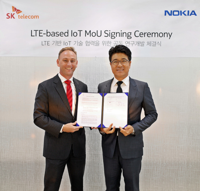 Park Jin-hyo, head of SKT’s network technology research and development center, and Andrew Cope, head of Nokia’s Korean office pose at the MOU signing ceremony held in Seoul Tuesday.(SKT)