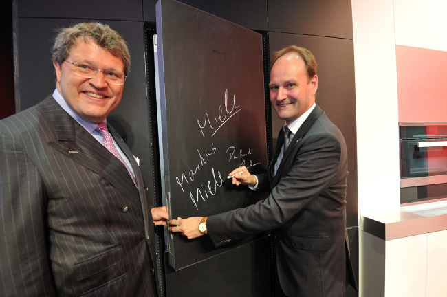 MIELE SHOWCASES NEW HOME APPLIANCES -- German electronics-maker Miele cochief executive Markus Miele (right) and Reinhard Zinkann pose with the firm’s fridge, Blackboard Edition, on Thursday at its exhibition booth at the IFA electronics trade show, set to kick off Friday in Berlin. Users can jot notes on the fridge’s surface with marker pens. (Miele)