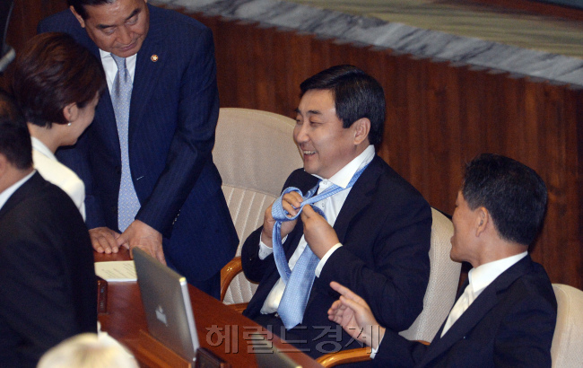 이종걸 새정치민주연합 원내대표가 지난 3일 교섭단체 대표연설에 앞서 넥타이를 바꿔 메며 웃고 있다. 안훈 기자/rosedale@heraldcorp.com