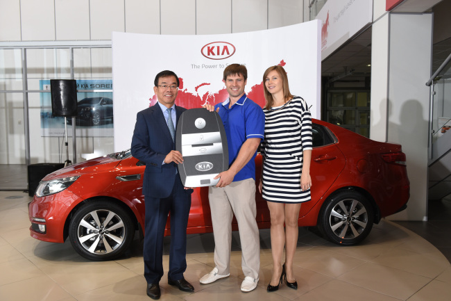 Kia Motors Russia president Kim Seong-hwan (left) poses with the 1 millionth Kia customer in Russia Ivan Lobanov (center) and his wife in a congratulatory ceremony held Thursday in Moscow. (Kia Motors)