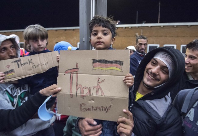 <YONHAP PHOTO-1137> Refugees arrive at the train station in Saalfeld, central Germany, Saturday, Sept. 5, 2015. Hundreds of refugees arrived in a train from Munich to be transported by busses to an accomodation centre. (AP Photo/Jens Meyer)/2015-09-06 06:29:17/ <저작권자 ⓒ 1980-2015 ㈜연합뉴스. 무단 전재 재배포 금지.>
Refugee boys carry signs reading “Thank Germany” after arriving on a special train from Austria, in Saalfeld, Germany, on Saturday. The refugees will be taken to accommodation in Saxony, Saxony-Anhalt and Thuringia Saalfeld by bus.    AP-Yonhap