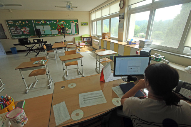 A South Korean schoolteacher is preparing for her class in an empty classroom. Yonhap