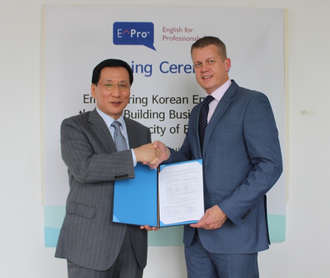 KPC chairman and CEO Hong Soon-jick (left) shakes hands with Pearson VUE senior vice president Gary Gates after signing a partnership deal at the Pearson headquarters in London last week.    KPC