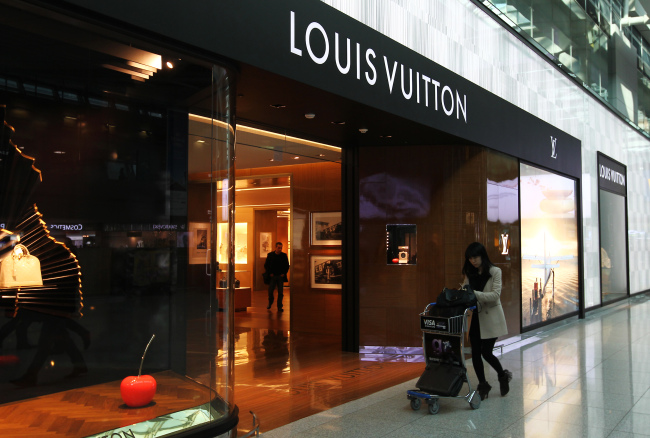 A woman walks past a Louis Vuitton store in the duty-free shopping area at Incheon International Airport.   Bloomberg
A woman walks past a Louis Vuitton store in the duty-free shopping area at Incheon International Airport.   Bloomberg