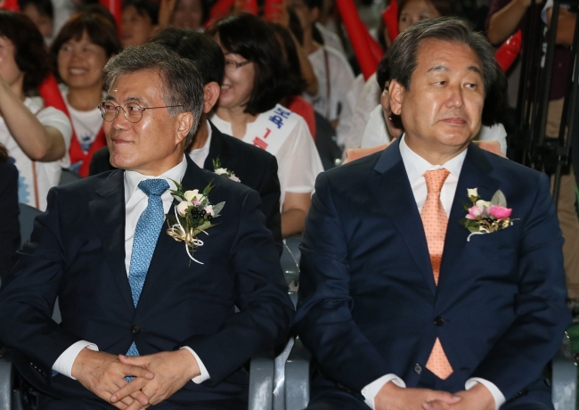 Rep. Moon Jae-in (left), the leader of the opposition New Politics Alliance for Democracy, and ruling Saenuri Party leader Rep. Kim Moo-sung sit next to each other in Jangchoong Stadium in Seoul on Wednesday.   Yonhap