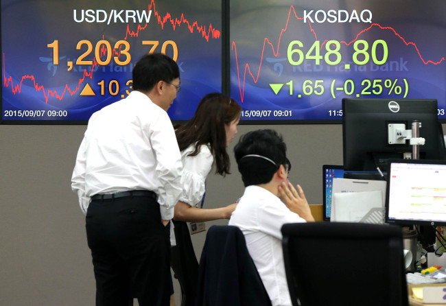 Currency dealers look at indices at KEB Hana Bank on Monday. (Yonhap)