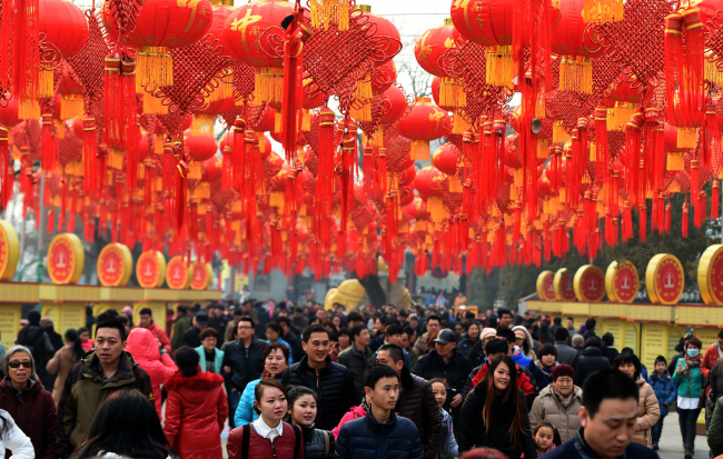People walk past a passage of red lanterns at Badachu Park in Beijing. (MCT)