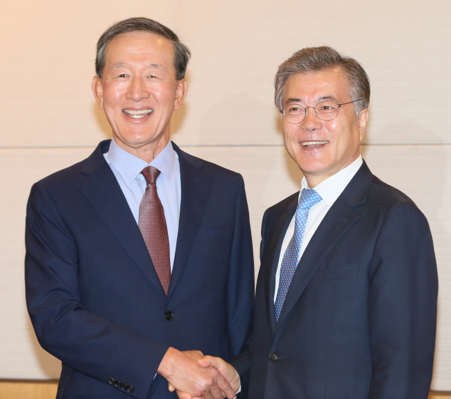 NPAD chairman Rep. Moon Jae-in (left) shakes hands with Federation of Korea Industry chairman Huh Chang-soo. Yonhap