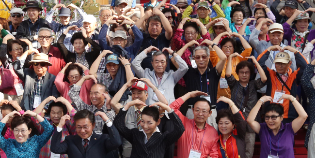 <YONHAP PHOTO-1841> 북녘 가족에게 사랑의 하트 (서울=연합뉴스) 홍해인 기자 = 대한적십자사와 한국철도공사 주최로 8일 오전 서울 봉래동 서울역에서 열린 이산가족 초청 '희망풍차 해피트레인' 행사에서 최연혜 코레일 사장(앞줄 왼쪽부터), 홍용표 통일부 장관, 김성주 대한적십자사 총재와 미상봉 이산가족들이 열차에 오르기 전 기념촬영을 하며 두 팔로 사랑의 하트를 그리고 있다. 이번 행사는 미상봉 이산가족 100명을 초청해 철원 DMZ 일대 백마고지역, 노동당사, 평화전망대 등을 둘러보며 참가자들이 고향에 대한 향수를 달랠 수 있도록 마련됐다. 2015.9.8 hihong@yna.co.kr/2015-09-08 14:02:57/ <저작권자 ⓒ 1980-2015 ㈜연합뉴스. 무단 전재 재배포 금지.>
